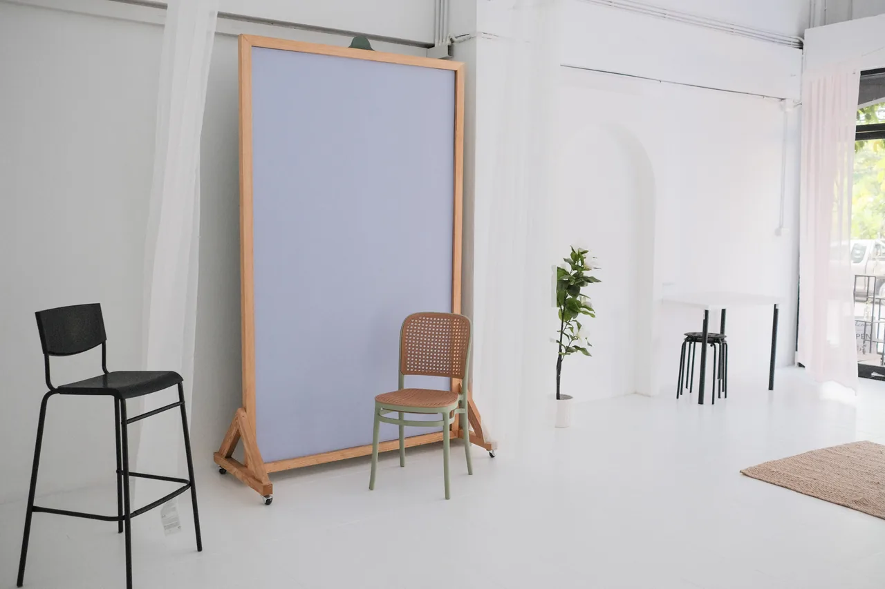 Black bar stool and cane chair in front of the lilac backdrop on the studio floor