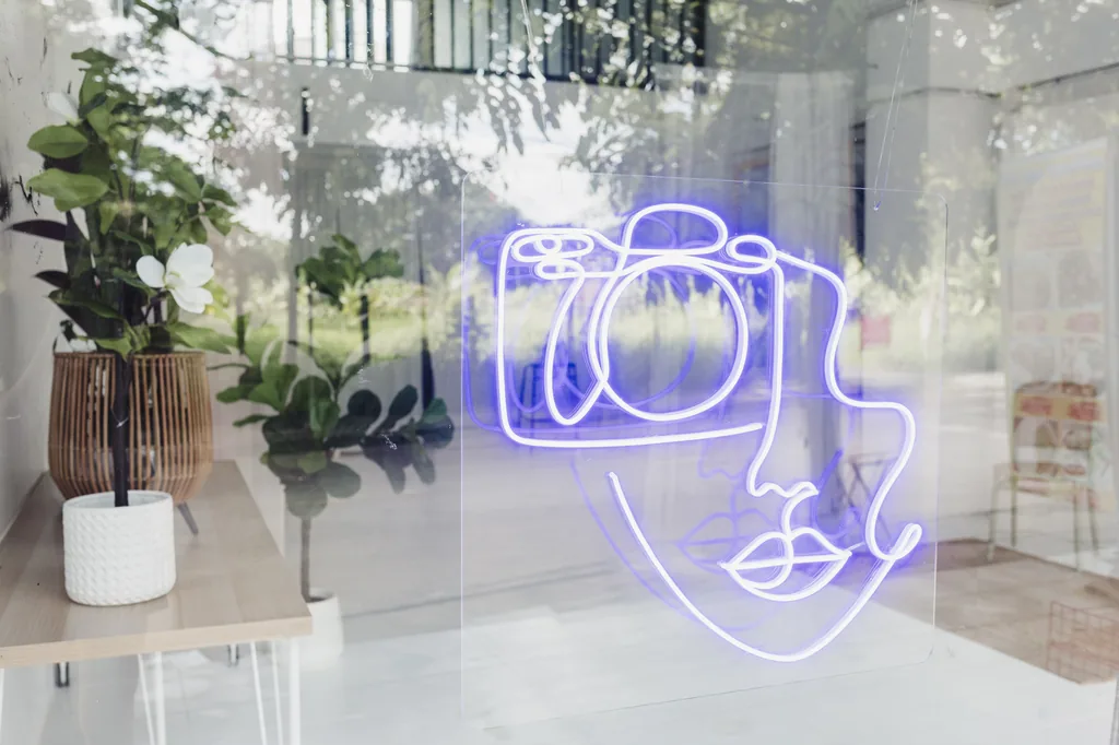 Neon camera logo glowing on the studio window