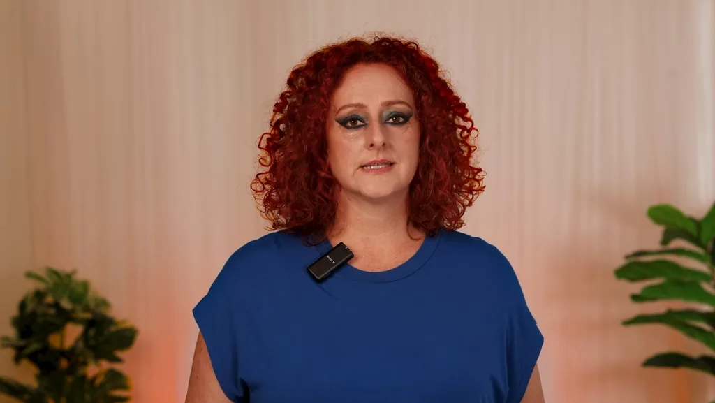 Presenter with red curly hair recording to camera