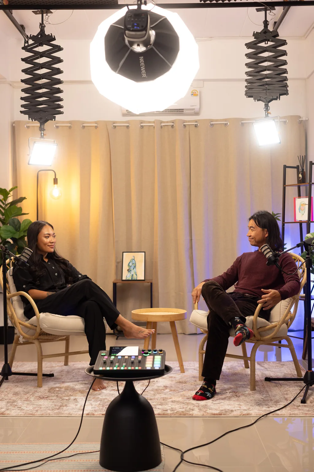 Two guests recording under a ring light and studio lighting rig