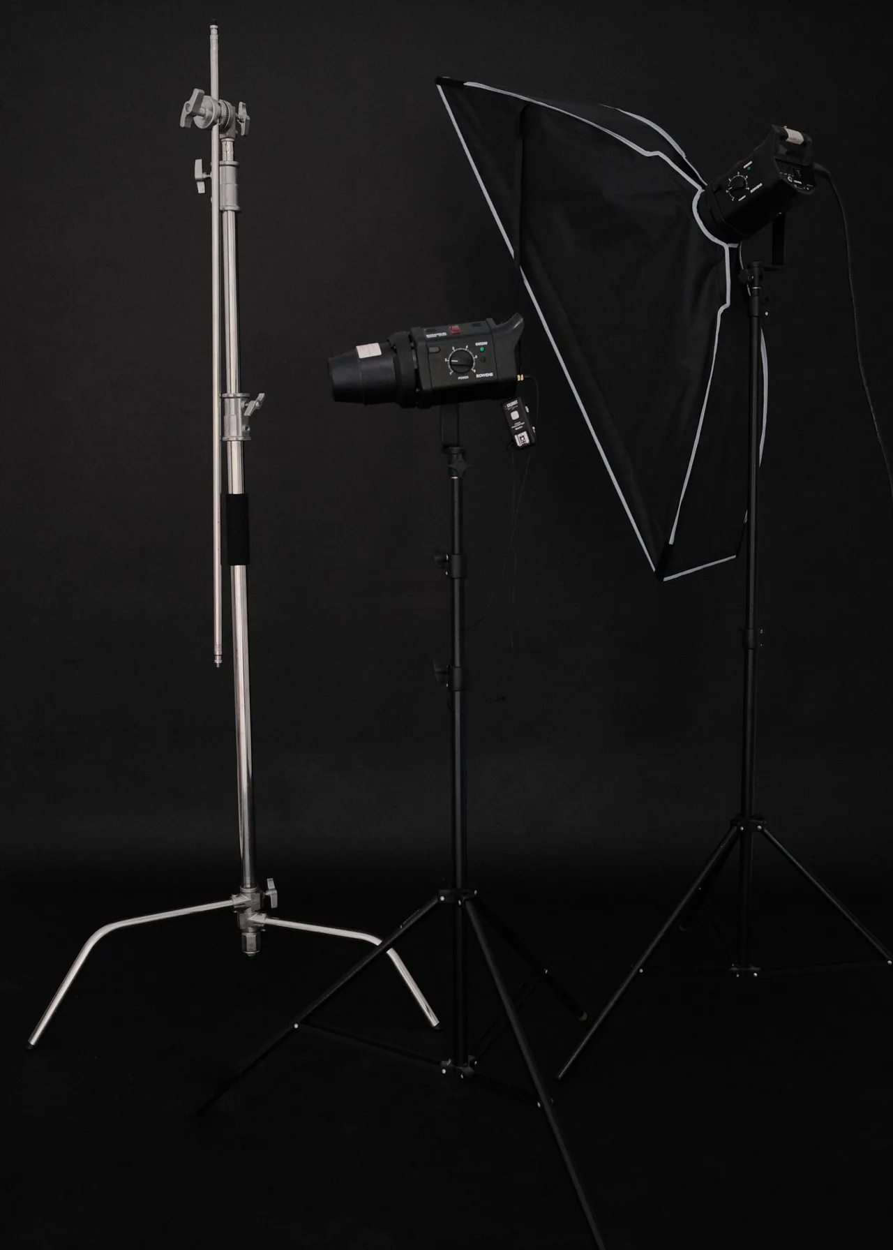 Softbox lights on stands against a black backdrop, ready for a production shoot