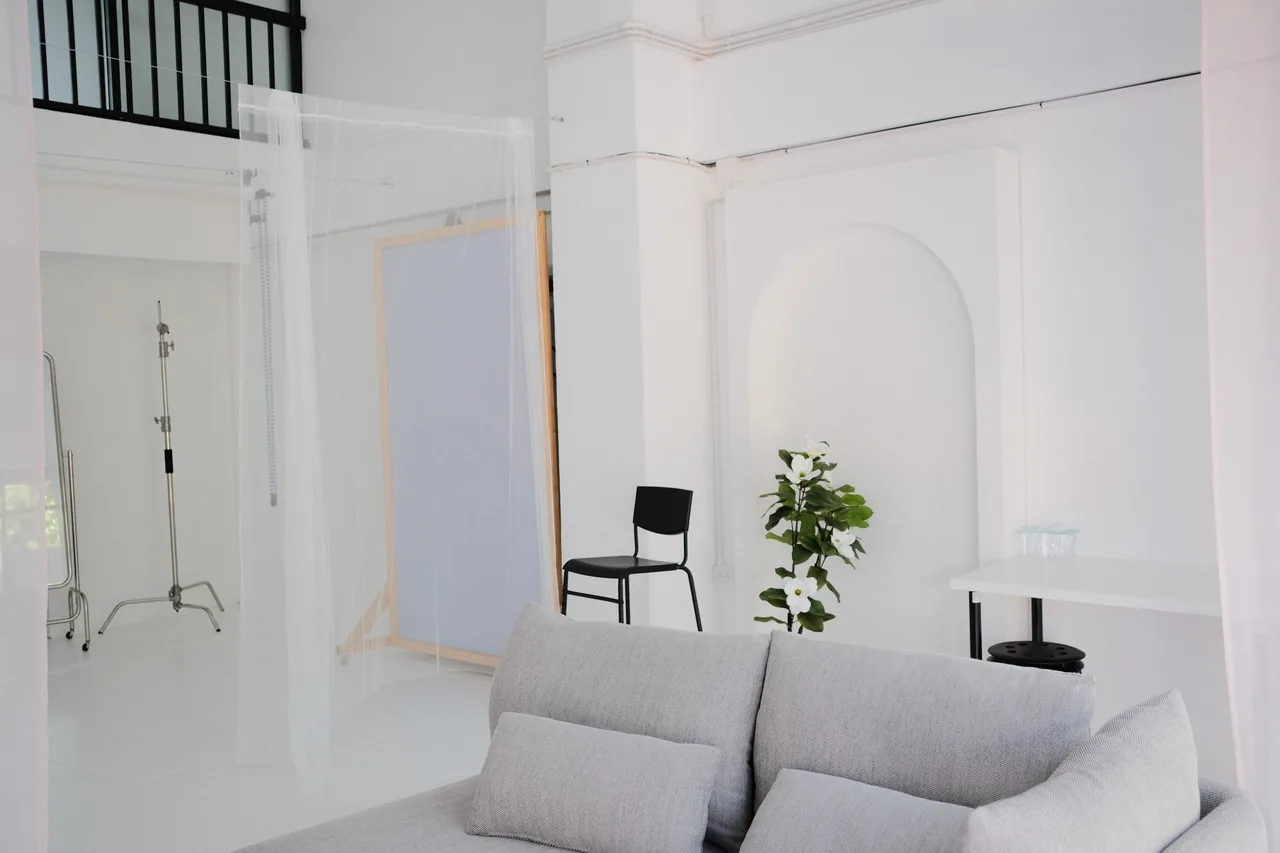 Wide view of the photo studio floor with sofa, backdrop and mezzanine