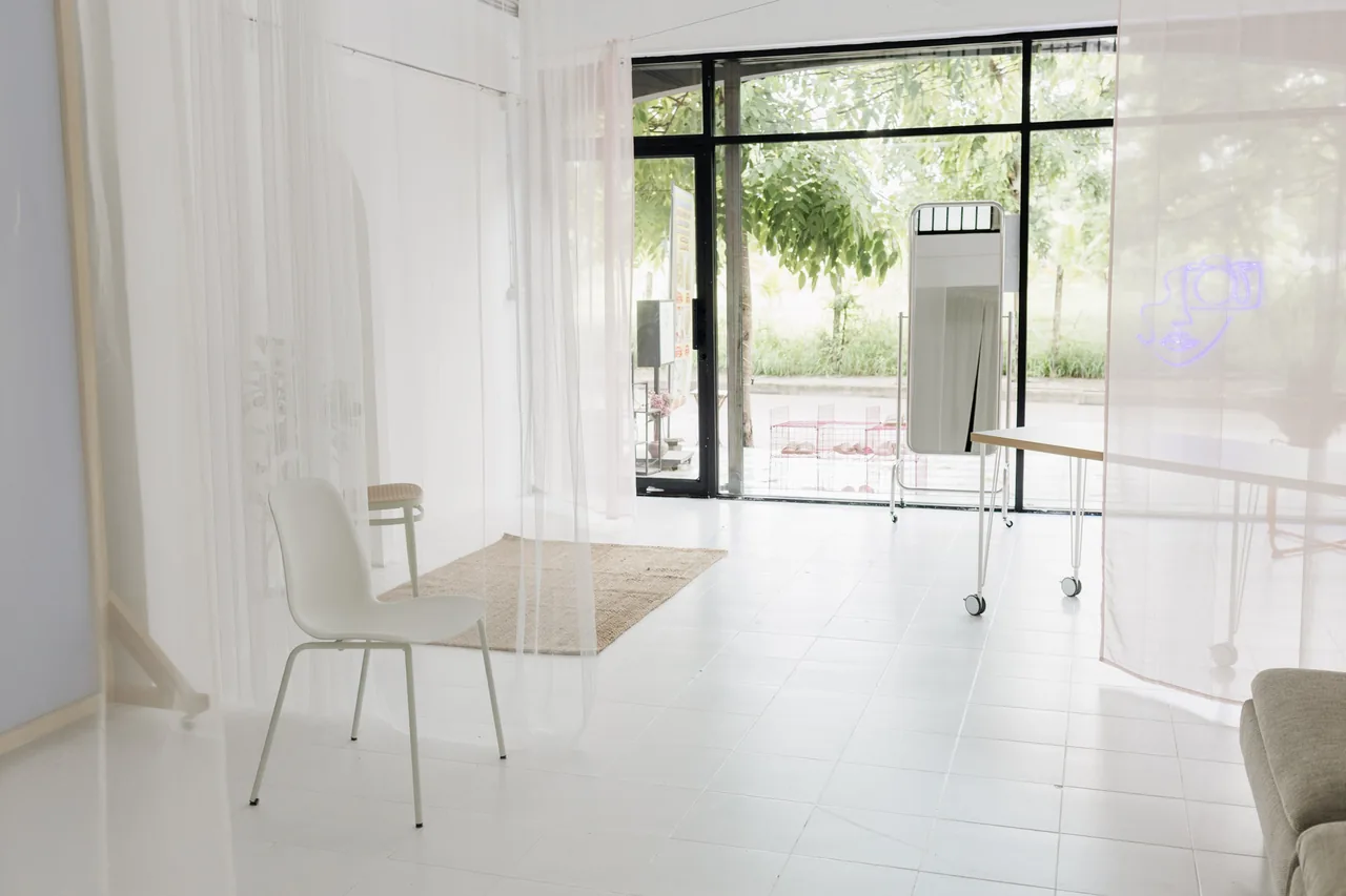 The photo studio floor with tall windows looking out onto green trees